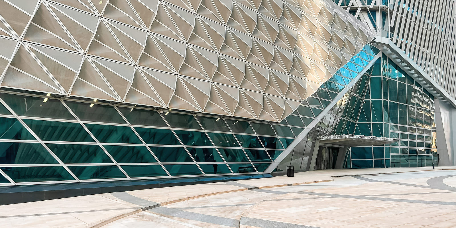 واجهة فاخرة بتصميم هندسي حديث ومجسمات مثلثية لبرج استثماري في مركز الملك عبد الله المالي